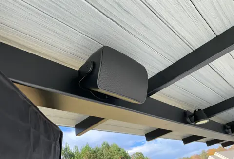 A speaker mounted to the side of a roof.